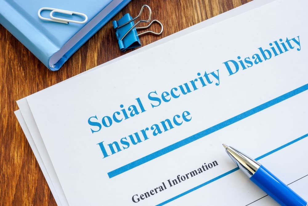Social Security Disability Insurance SSDI application form and pen.